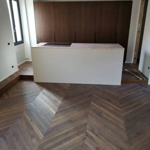 Parquet a spina francese tinto noce scuro su lavorazione di piallatura a manoParquet in doghe di grande formato in prima scelta di olmo olio cerato
